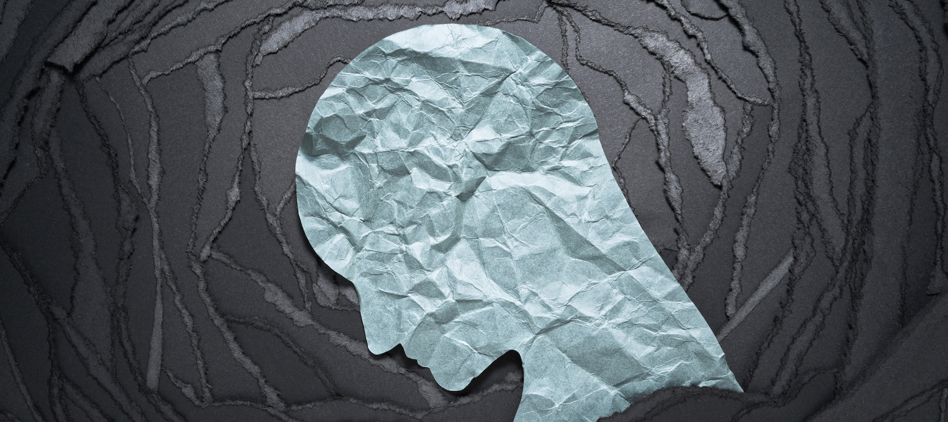 Silhouette of depressed and anxiety person head. Negative emotion image. Person head shaped paper on black torn paper background. Teen girl with anxiety